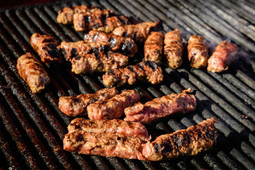 Grilled meat rolls called Mici or Mititei, traditional fresh Romanian bbq grill food cooked on the barbeque at a street food market