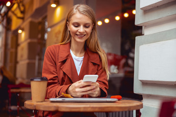 High-spirited pretty millennial woman using a phone