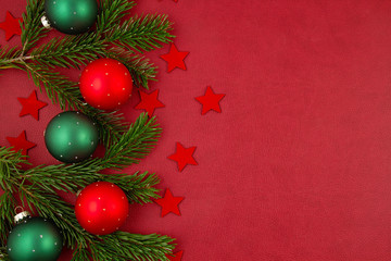 Christmas decoration with xmas ornaments, pine tree, gifts with copy space over the red background