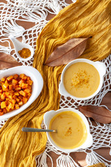 Pumpkin cream spiced with curry in a white bowl with roasted pumpkin. Close Up