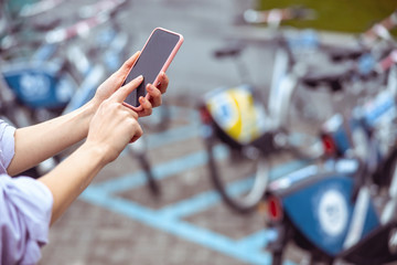Female with a cellphone hiring a social bike