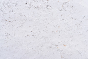 cracked and weathered white paint and plaster on wall background