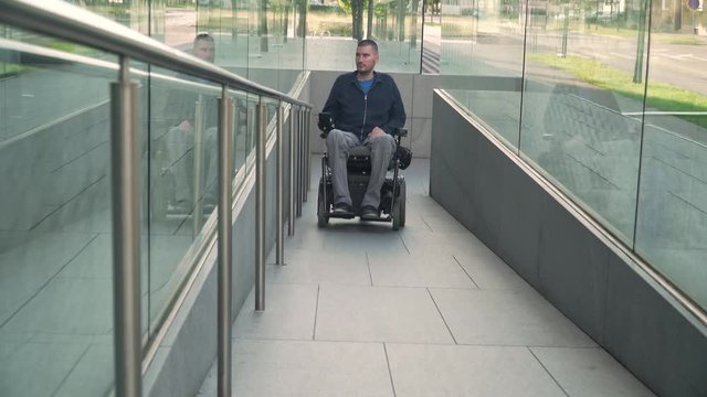 4k resolution of a man on electric wheelchair using a ramp. Accessibility concept