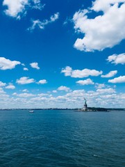 Clear sky with beautiful clouds and Statue of Liberty from long distance