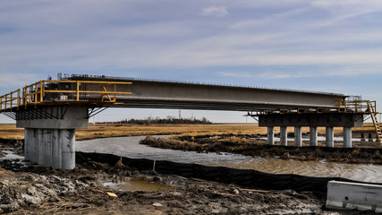 Concrete girders installation  on a bridge abutment and center pier as part of a new interchange in southern Saskatchewan Canada for a new freeway system and extension of the Trans-Canada Highway