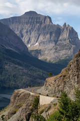 Beautiful View of Scenic Highway with American Rocky Mountain Landscape in the background during a Cloudy Summer Morning. Taken in Glacier National Park, Montana, United States.
