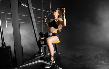 Naklejka na ściany i meble Athletic girl does exercises using sports equipment in a gym.