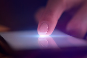 Finger touching phone with dark background with copyspace