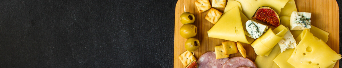 cheese board (different types of cheese plate appetizers , sausage, ham, olives, greens and more) menu concept. food background. copy space. Top view