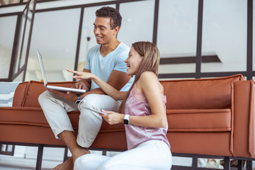 Positive delighted long haired girl pointing at her laptop