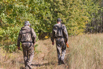 Hunters men with weapons go hunting
