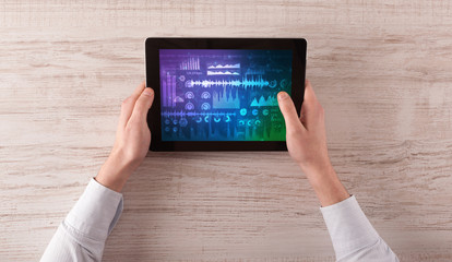 Hand touching tablet with waveforms and sound design concept