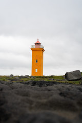 Bright orange lighthouse stands alone on the coast © Nate Hamill