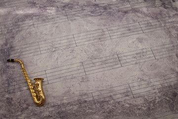 Naklejka premium Fondo partitura con instrumento en miniatura
