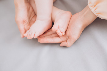 Obraz na płótnie Canvas little baby lies parents touch gently legs