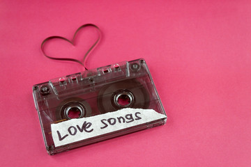 vintage old film music cassette on a trendy pink background with the inscription love song, background music, music lovers, heart