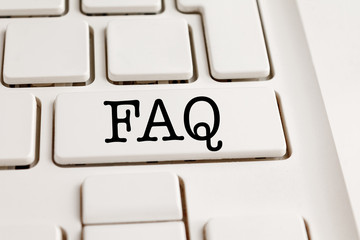 white laptop computer keyboard with faq inscription on the key, help and support concept