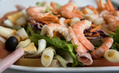 Fresh salad with shrimp, red cabbage and carrots .