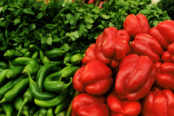 Hot green peppers and sweet red peppers on the market.  Vegetables for a vegetarian salad.