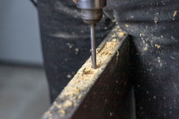 Installing a door, Install a door lock, use a milling saw, a carpenter close-up holds a green electric drill