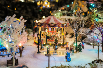 Fototapeta na wymiar Miniature of winter scene with Christmas merry go round, trees, Christmas concept.