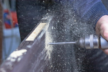 Installing a door, Install a door lock, use a milling saw, a carpenter close-up holds a green...