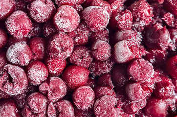 frozen cherry red berry background in ice with snowflakes