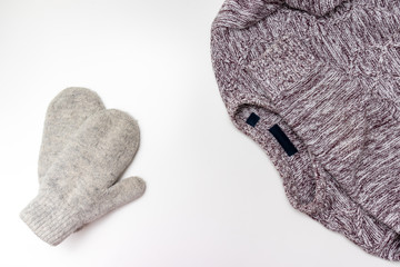 Brown knitted casual sweater, pullover and winter mittens on white background with copy space