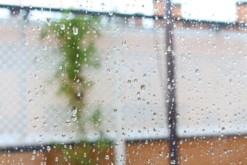 Gotas de lluvia sobre el cristal de una ventana durante un día lluvioso y frío de invierno u otoño