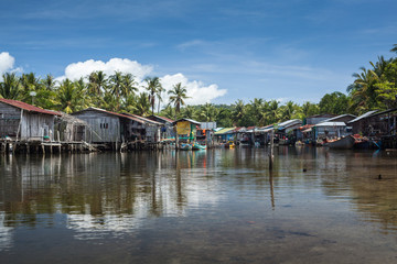 Obraz premium Riverside houses in the unspoilt traditional fishing village of Prek Svay, Koh Rong island, Cambodia, south east Asia, on a calm sunny day.