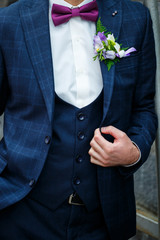 Man puts on a wedding suit and accessories on the wedding day.