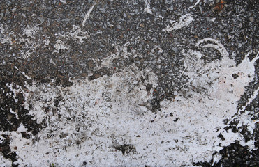 A spot of white paint on old gray asphalt. Texture for creative design.