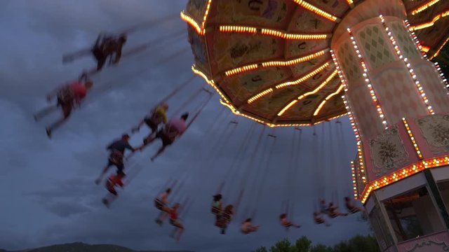 Low angle view of people riding chain swing ride at amusement park / Kaysville, Utah, United States