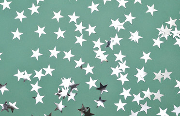 Festive background.Glitter stars on mint color background.