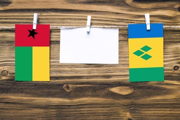 Hanging flags of Guinea Bissau and Saint Vincent And The Grenadines attached to rope with clothes...