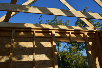 Construction of a wooden frame building. Small garden house with trees outside the window.