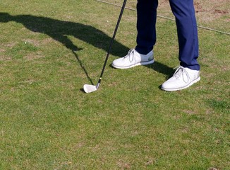 Golfer mit Schläger nd Ball auf Rasen