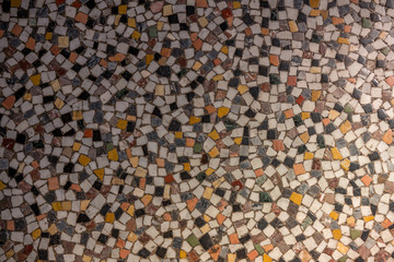 Old mosaic floor with different colored natural stones.