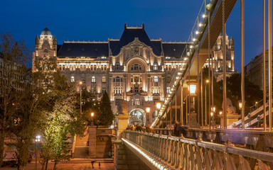 Obraz premium Blue hour in Budapest with Chain bridge. Including Danube river and Gresham palace. St Stephen basilica appear in the background.