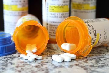 Precription bottles of pain pills on a granite countertop.  - obrazy, fototapety, plakaty
