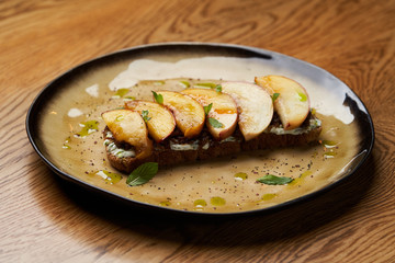 Traditional italian bruschetta with duck fillet, cream cheese and peach, close-up