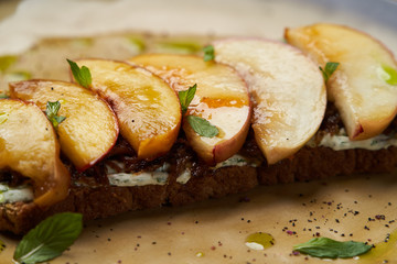 Traditional italian bruschetta with duck fillet, cream cheese and peach, close-up
