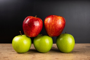 red and green apples on wooden table