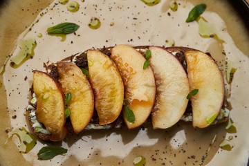 Traditional italian bruschetta with duck fillet, cream cheese and peach, close-up