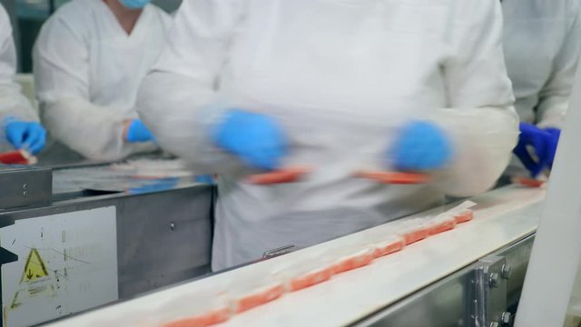 Factory technicians are removing crab sticks from the belt