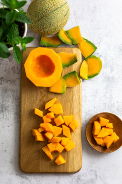 Directly above shot of cantaloupe slices by plant on table