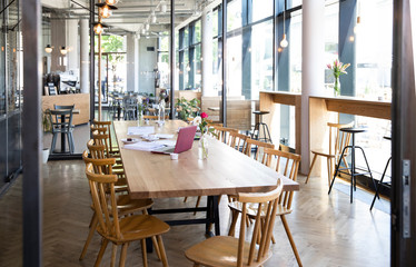 Laptop and documents on table in a modern cafe