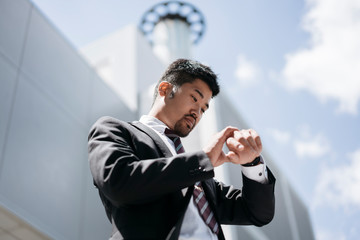 Young businessman in the city checking the time