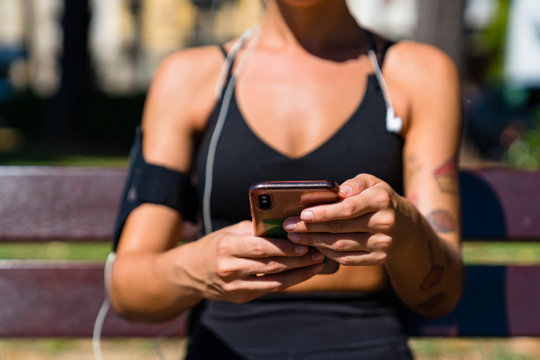 Close-up of sporty young woman holding cell phone