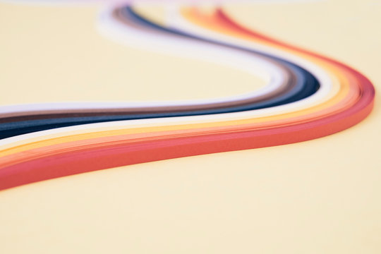 Close-up of quilling papers with swirl pattern on beige background